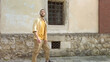 © Honchar - Side view of adult male traveler in yellow shirt walks along a narrow old street. Tourism during quarantine