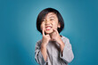 © KahLoong - Beautiful smiling asian little kid show his teeth. Empty space in studio shot isolated on colorful blue background. Education concept for school.