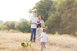© Sofiia Shunkina - Family with children walking outdoors in summer field at sunset. Father, mother and two children sons having fun in summer field. People, family day and lifestyle concept