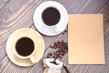 cup of coffee with a book on a wooden table