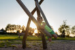 Boy laughing on a swing at sunset.