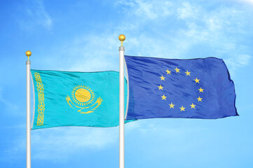 kazakhstan and european union two flags on flagpoles and blue sky