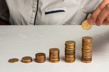 Wall Mural - stack of coins on a white wooden table