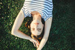 girl lies on the grass in the sun, top view