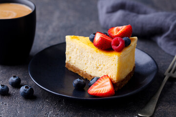 Canvas Print - Cheesecake dessrt with fresh berries and cup of coffee. Dark background. Close up.