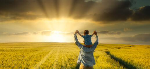 father and son in wheat field, child sitting on his fathers shoulders