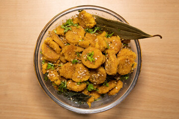 Sticker - Gattey ki sabji Indian Delicious Cuisine of Rajasthan made with Roasted Boiled Gram Flour mixed with Seasame Seeds and Cumin Seeds in Glass bowl and Frying Pan decorated with Leaf Spatula