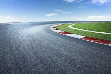 Asphalt race track with dramatic turning curve corner.