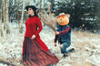 Halloween Scarecrow with a pumpkin on its head tries to give a bouquet of dried herbs to a witch