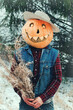 man in a Halloween costume depicts a Scarecrow with a dry bouquet in his hands