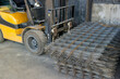 forklift carrying a stack of rebar mesh