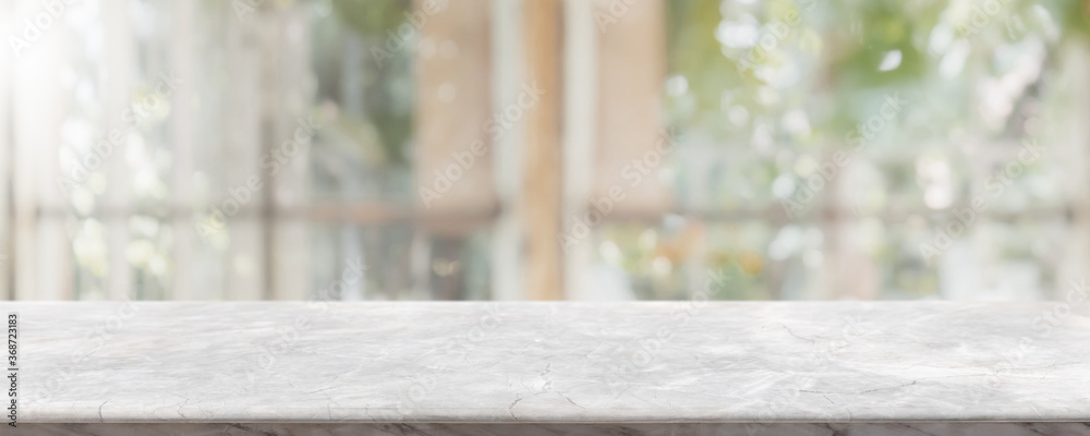 Empty white stone marble table top and blurred of interior restaurant with window view green from tree garden background background - can used for display or montage your products. - obrazy, fototapety, plakaty 