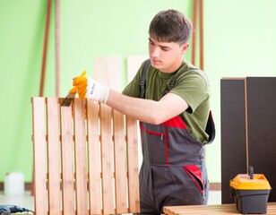 Wall Mural - Young man carpenter working in workshop