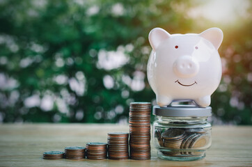 Money coin stack growing graph with piggy bank and coins in jug glass