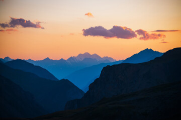 Wall Mural - colorful dawn landscape with beautiful mountains silhouettes and golden gradient sky with lilac clou