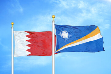 bahrain and marshall islands two flags on flagpoles and blue sky