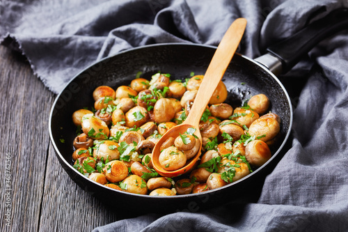 Fotografía Sauteed garlic white mushrooms on a pan, close-up