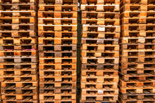 A Lot Stacks Of Used  Wooden Pallets Of Euro Type On Warehouse Is Ready For Recycling. Industrial Background. Close-up.