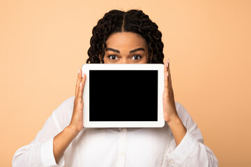 African Lady Showing Digital Tablet Empty Screen Over Beige Background