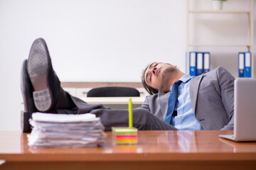 Young male employee sleeping in the office