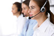 © rogerphoto - Call center. Group of operators at work. Focus at beautiful business woman in headset