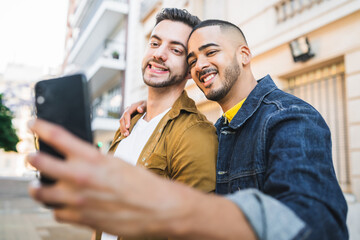 Wall Mural - Gay couple taking a selfie in the street.