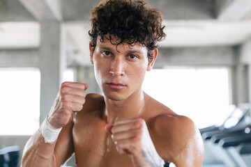 Portrait of boxer standing guard position ready to fight. sexy topless man do exercise workout and boxing in gym fitness for better health and quality of life. sweating and looking at camera