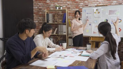 Wall Mural - Young man and woman coworkers in creative team meeting. female employee conducting business presentation to colleagues while working in office. group of small startup business people discussing plan