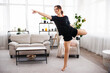 © Admiral - Beautiful young fitness woman or ballet dancer at home, doing gymnastics exercises in living room. Copy space