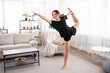 © Admiral - Beautiful young fitness woman or ballet dancer at home, doing gymnastics exercises in living room. Copy space
