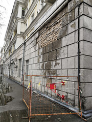 Canvas Print - You can see the severe damage to the old wall of the house with large pieces of plaster falling nearby