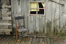 Old Wooden Chair On The Porch Of Old Wooden Building