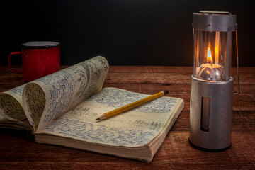 Wall Mural - Vintage expedition journal on a picnic table with a candle lantern tea mug. Travel log from 1974 paddling trip in Poland - handwriting and drawing in pencil (property release attached).