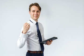 Portrait of a businessman raised his hand clenched into a fist, in the other hand an electronic tablet. White background