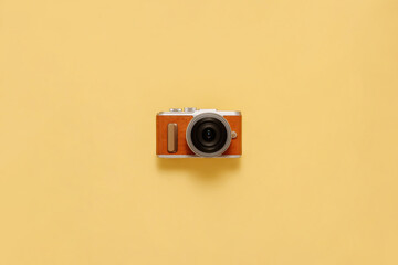 Photo camera on yellow background with drop shadow flat lay. Travel or vacation concept top view composition.