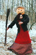 witch and a Halloween Scarecrow in the woods