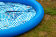 A deflated inflatable pool on the backyard lawn.