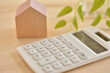 Calculator and house on a wooden table