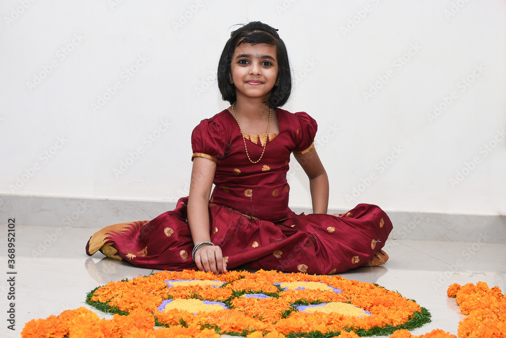 Kerala Onam festival, happy young Indian girl child, wearing traditional  dress putting flower bed or Pookalam decoration floral pattern on Onam,  Vishu, Diwali celebration, India. Indian festival. Stock Photo | Adobe Stock