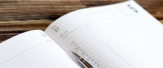 Poster - Opened lined diary with a ball pen on wooden background