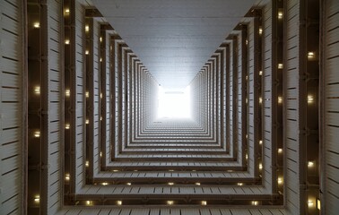 Low angle diminishing perspective view from the atrium of a multistorey public housing in Hong Kong, with sunlight cast from the top and the multilayers of corridors making a unique geometric pattern