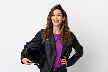 Wall Mural - Young caucasian woman holding a motorcycle helmet posing with arms at hip and smiling