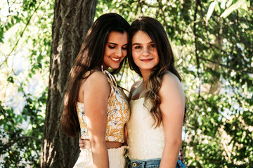 two young women friends in the forest with trees in the background