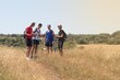 © Avelino - young people talking during a walk with the trekking sticks through the countryside and the Camino de Santiago