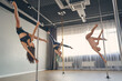 Group of beautiful young women performing pole dance tricks