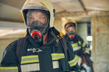 Handsome man at the work wearing protective uniform with yellow helmet