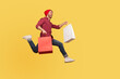 © khosrork - Enthusiastic joyful hipster trendy guy running in air with shopping bags in hands, hurrying to catch sale, flying and rushing for thrift discount. full length studio shot isolated on yellow background