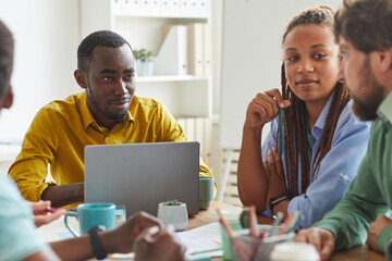 Wall Mural - portrait of creative african-american man using laptop while working on team project with multi-ethn