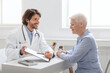 © Prostock-studio - Cheerful doctor showing good test results to senior patient