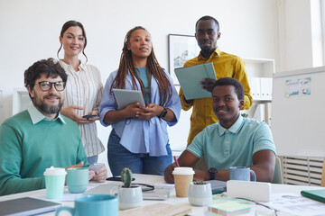 Wall Mural - Low angle portrait of multi-ethnic business team looking at camera while posing in conference room during meeting, copy space